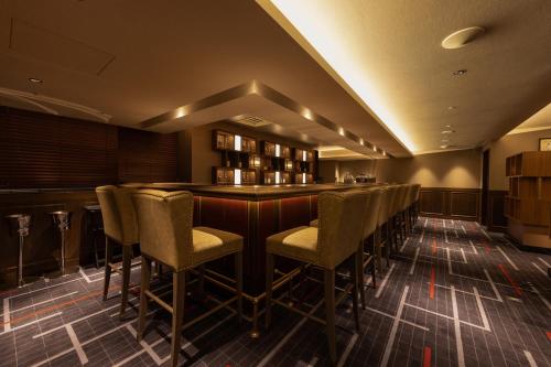 a bar with chairs and a counter in a room at Hotel Metropolitan Premier Taipei in Taipei