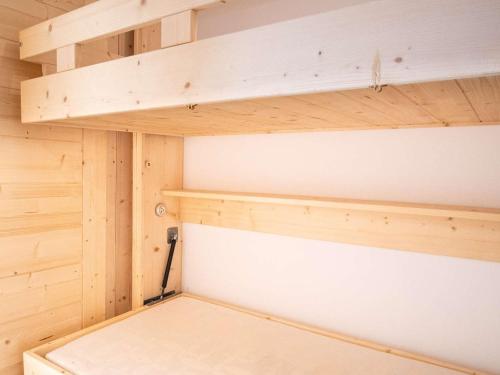 Cette petite cabine est dotée de murs et d'étagères en bois. dans l'établissement Bel appartement rénové 4 pers, cuisine équipée, proche commerces - FR-1-637-56, à Val Thorens