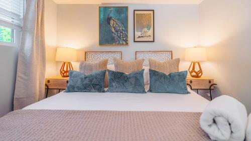 ein Schlafzimmer mit einem großen Bett mit blauen Kissen in der Unterkunft Hip Duplex Near UAB Perfect For Groups in Birmingham