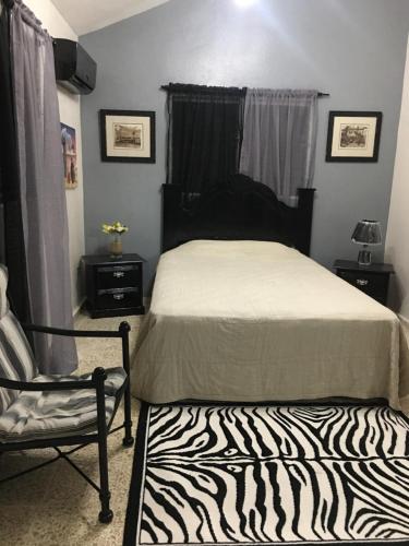 a bedroom with a zebra print bed and a chair at Hacienda de Flores in Guayacanes