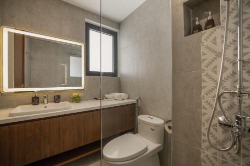 uma casa de banho com um WC, um lavatório e um espelho. em Maison Vy Anh Hotel & Apartment em Da Nang