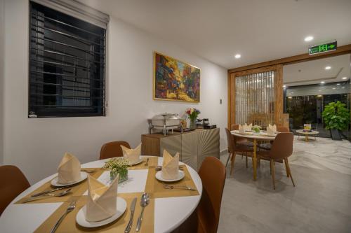 uma sala de jantar com duas mesas e cadeiras com chapéus em Maison Vy Anh Hotel & Apartment em Da Nang