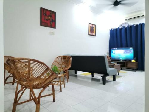 a living room with a piano and chairs and a tv at UIA Younee Kuantan Homestay 3R2B 9pax 5 min to town in Kuantan