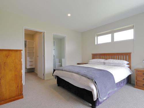 a bedroom with a large bed and a window at Fiordland Getaway - Te Anau Holiday Home in Te Anau
