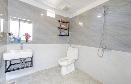 a bathroom with a toilet and a sink and a shower at Homestay Vuon Phap BMT in Buon Ma Thuot