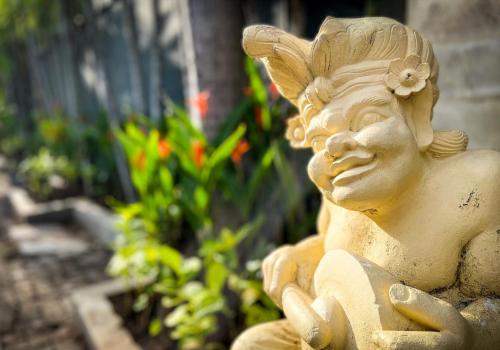 a statue of a woman sitting in a garden at Villa Alu Lima in Seminyak