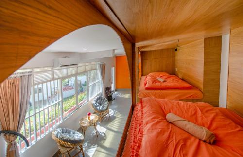 two beds in a room with a window at Homestay Vuon Phap BMT in Buon Ma Thuot