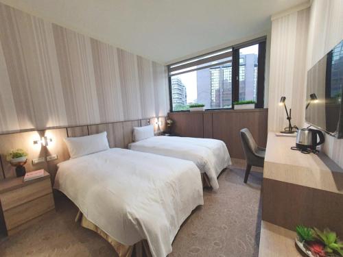 een hotelkamer met 2 bedden en een raam bij Grace Hotel Dunbei in Taipei