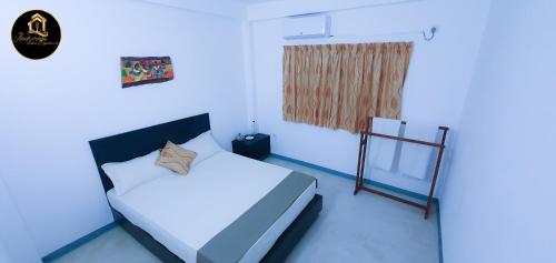 a blue room with a bed and a window at The Anchorage Holiday Apartments - Negombo in Negombo