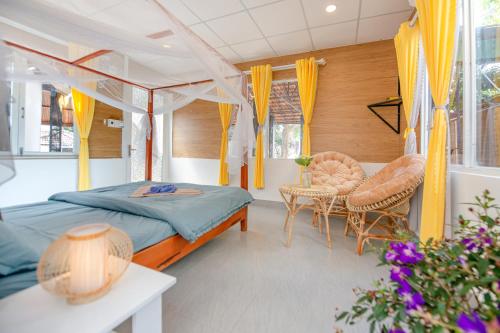 a bedroom with a bed and a table and chairs at Homestay Vuon Phap BMT in Buon Ma Thuot