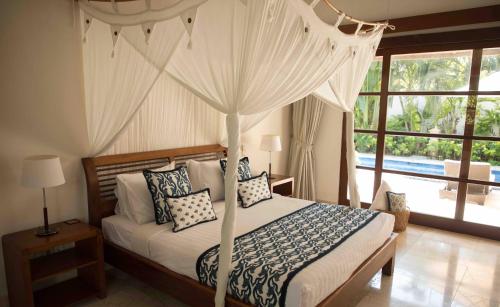1 dormitorio con 1 cama con dosel en Villa Alu Lima, en Seminyak