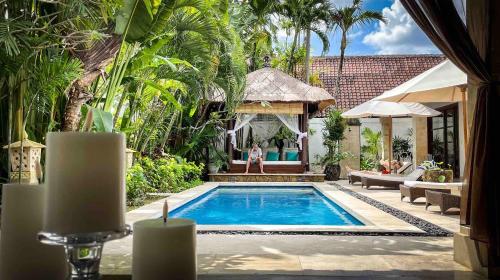 a swimming pool in a backyard with a villa at Villa Alu Lima in Seminyak