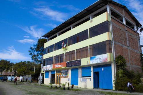 a building on a street with people walking in front of it at Hinkiori Inn - Hotel Manu in Pillcopata