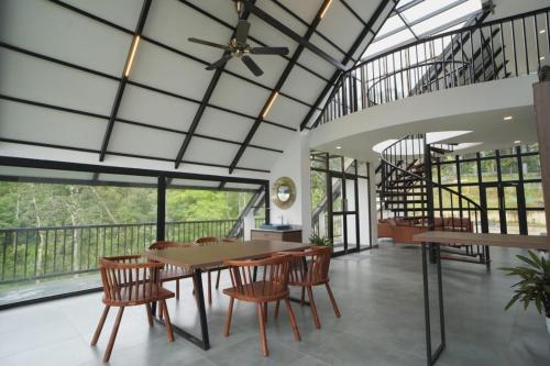 Padinjarathara的住宿－Nammal Resorts，一间设有玻璃天花板和桌椅的用餐室