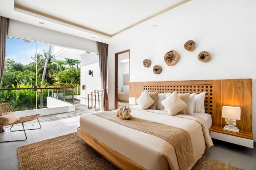 a bedroom with a large bed and a large window at Villa GoodFellas by BaliSuperHost in Seminyak