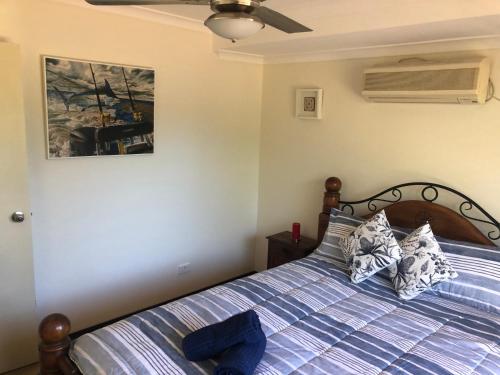 um quarto com uma cama com um edredão azul listrado em Superior Reef to Range em Exmouth