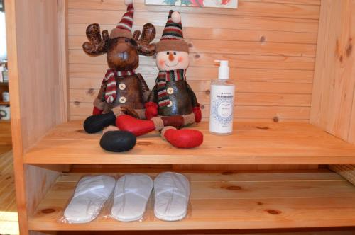 a shelf with two stuffed animals and a snowman at AB1 Log House 愛知県 in Seto