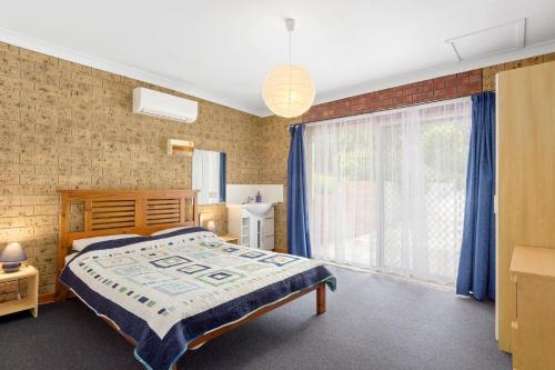 ein Schlafzimmer mit einem Bett und einem großen Fenster in der Unterkunft Broadbeach Retreat 32 Broadbeach Drive in Carrickalinga