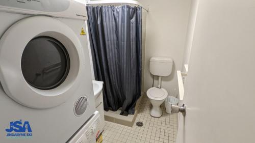 - un lave-linge dans la salle de bains pourvue de toilettes dans l'établissement Mountain View Kirwan 47, à Jindabyne