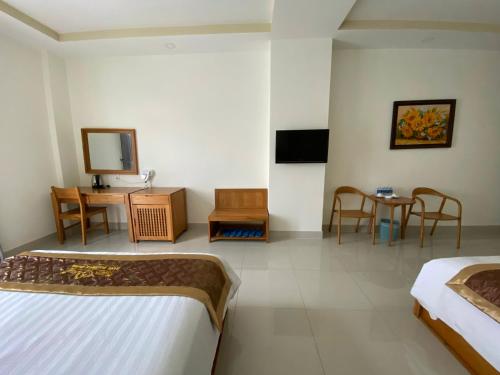 a hotel room with two beds and a table and chairs at BĂNG BOUTIQUE HOTEL in Thu Dau Mot