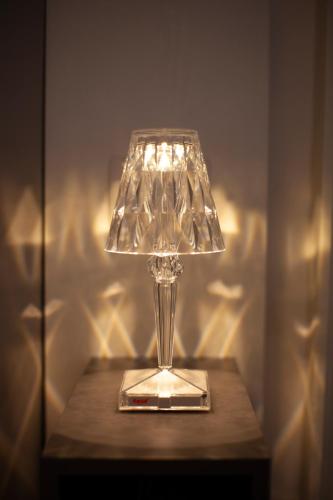 a glass lamp sitting on a wooden table at CasaPaola b&b Rooms in Acireale