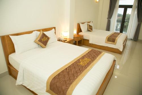 a hotel room with two beds and a window at BĂNG BOUTIQUE HOTEL in Thu Dau Mot