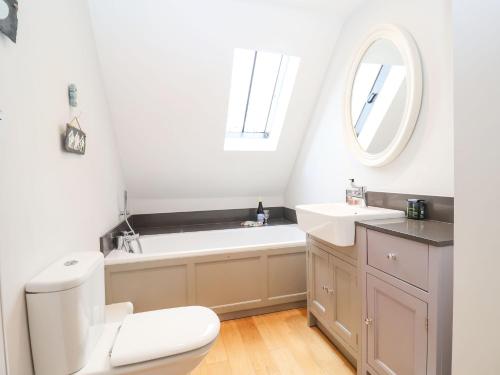 a bathroom with a tub and a toilet and a sink at Saffron, Blythview in Blythburgh