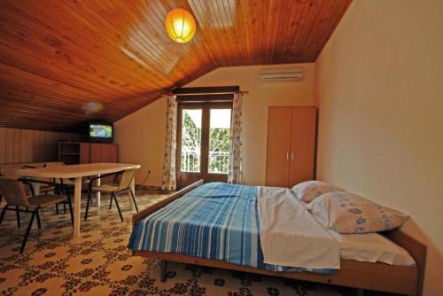 Schlafzimmer mit einem Bett und einem Esstisch in der Unterkunft Apartments Denko - with pool in Kali