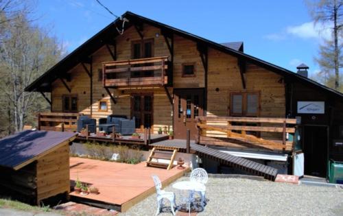 a large log cabin with a deck and a patio at Alpages - Vacation STAY 11099 in Myoko