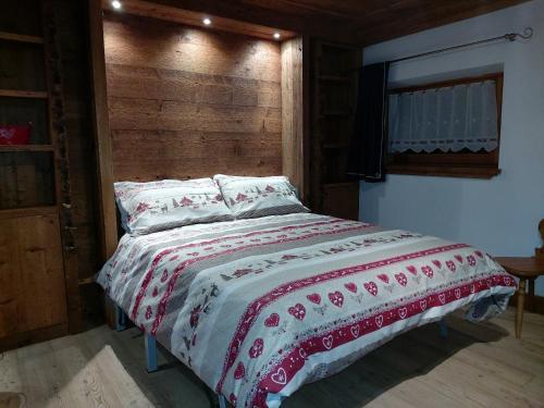 een bed in een slaapkamer met een houten hoofdeinde bij APPARTAMENTO STELLA ALPINA in Cortina dʼAmpezzo