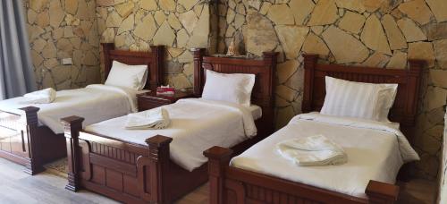 un grupo de 3 camas en una habitación en jabal shams view stay نزل إطلالة جبل شمس, en Al Ḩamrāʼ