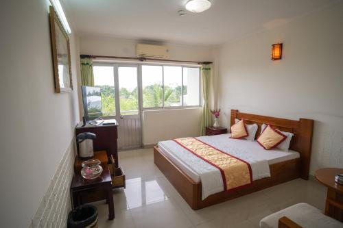 a bedroom with a bed and a large window at Khách Sạn Bông Sen in Vị Thanh