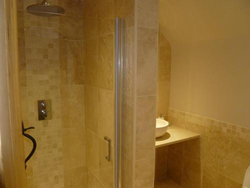 a shower with a glass door in a bathroom at Hunger Barn in Norwell