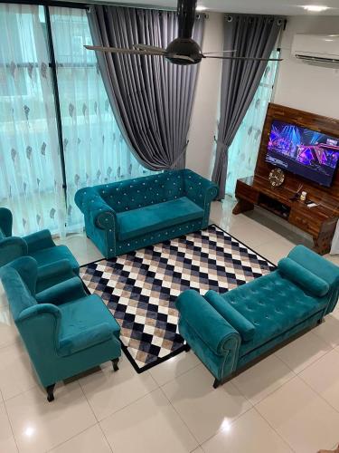 uma sala de estar com um sofá e cadeiras e uma televisão em TERATAK QASEH Meru em Kapar