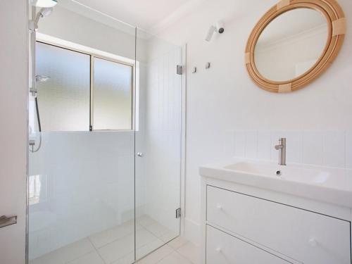 a bathroom with a shower and a sink and a mirror at Nalu - Hosted by Burleigh Letting in Gold Coast