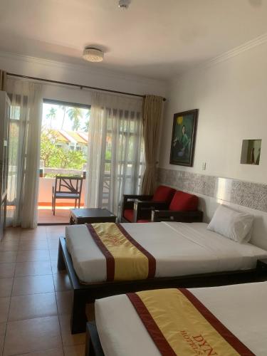 a bedroom with two beds and a living room at DYNASTY MUINE RESORT in Ấp Thiện Phước