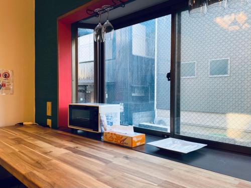 a room with a table with a tv and a window at アニメーションの起源地にある大泉学園ヴィラ in Katayama