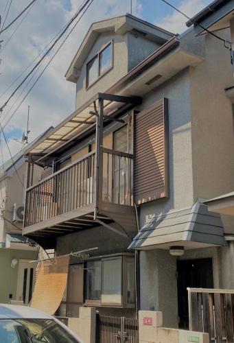 a house with a balcony and a porch at アニメーションの起源地にある大泉学園ヴィラ in Katayama