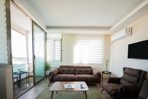 a living room with two couches and a tv at ABC Apart Hotel in Antalya