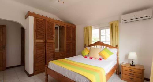a bedroom with a bed with a wooden headboard at Villa Confort in Grand'Anse Praslin