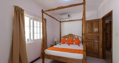 a bedroom with a canopy bed and a window at Villa Confort in Grand'Anse Praslin