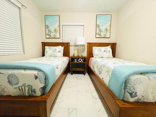 dos camas sentadas una al lado de la otra en un dormitorio en 4 miles to Siesta Key Beach #1 in America, en Sarasota