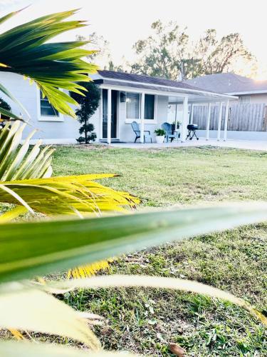 a white house with a yard with a house at 4 miles to Siesta Key Beach #1 in America in Sarasota
