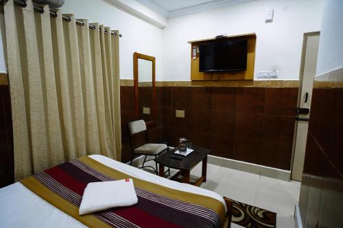 a hotel room with a bed and a tv at HOTEL PRAKAASH RESIDENCY in Mysore