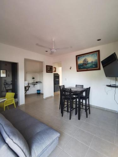 - un salon avec une table et des chaises dans l'établissement La casita del árbol, amplia y cómoda en barrio familiar, à Campeche