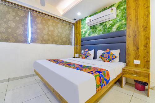 um quarto com uma cama num quarto com uma janela em FabHotel Royal King em Ahmedabad