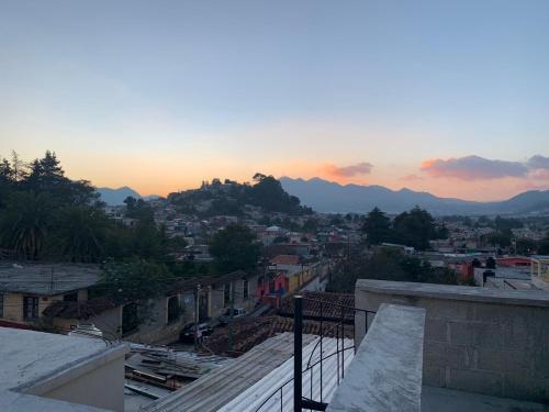 a view of a city at sunset from a balcony at Hostal 23 in San Cristóbal de Las Casas