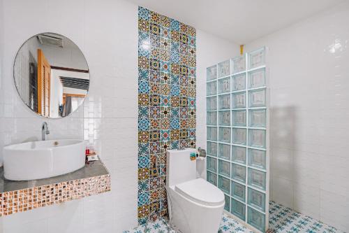La salle de bains est pourvue de toilettes, d'un lavabo et d'un miroir. dans l'établissement The Villager Fishermans Village, à Bophut 