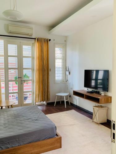 een slaapkamer met een bed en een flatscreen-tv bij M house 26 Yen Phu 5th in Hanoi