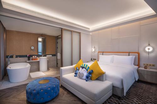 pokój hotelowy z łóżkiem i kanapą w obiekcie Voco Chongqing Chaotianmen w mieście Chongqing